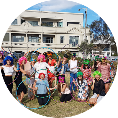 Hula Hoop Hens Party in St Kilda with group of friends with hula hoops dressed up in Eighties wigs and lycra