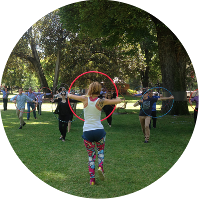 Donna Sparx teaching hula hoops to a group of people as part of a corporate team building activity